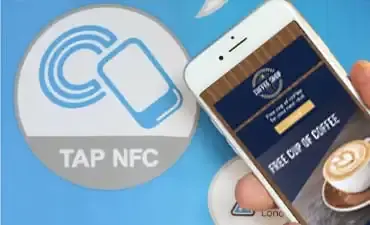El celular tocando la etiqueta NFC con un Cupón Digital en el celular.